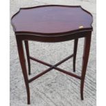 A mahogany serpentine galleried top silver table, on splay supports united by an 'X' stretcher,
