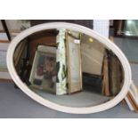 An oval white painted wall mirror with bevelled plate, 36" x 25"