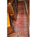 A vintage Persian tribal runner with nine star medallions on a red ground with animals and birds,