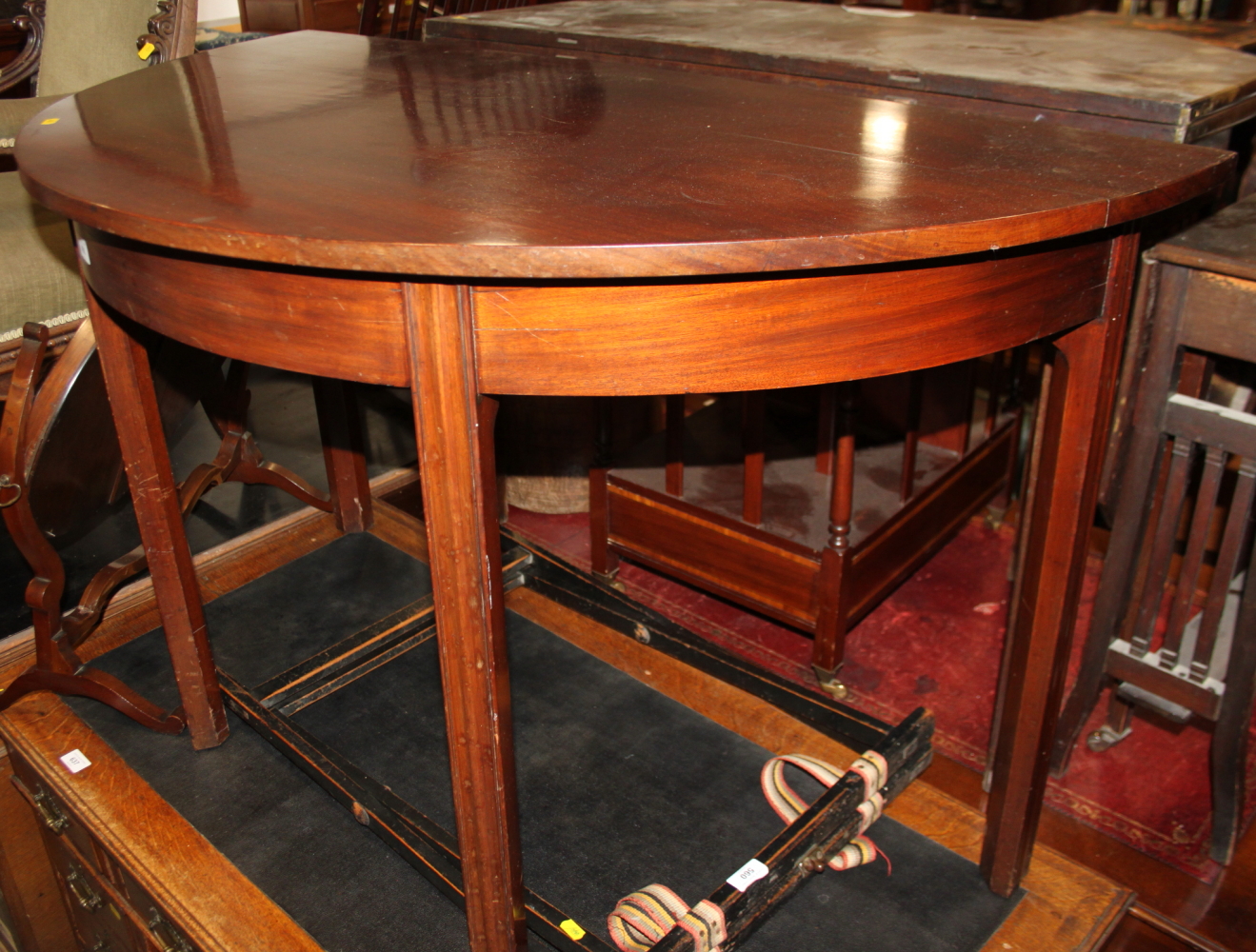 A 19th century mahogany semicircular side table, on chamfered and moulded supports, 46" wide x 23"