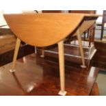 A 1950s Ercol elm oval top drop leaf dining table, on splay supports (design 7834), 45" x 49"