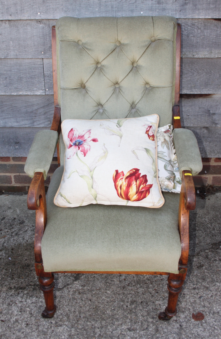 A late 19th century polished as walnut scroll arm chair, upholstered in a sage green fabric, on