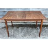 A 1950s Gordon Russell style teak extending dining table with extra leaf, on slender square taper
