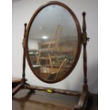 A mahogany oval swing frame toilet mirror, on skeleton stand, 17" wide