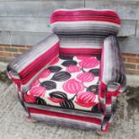 A 1930s deep seat armchair, upholstered in a modern floral and striped fabric