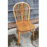 A light oak finish Windsor wheelback dining chair