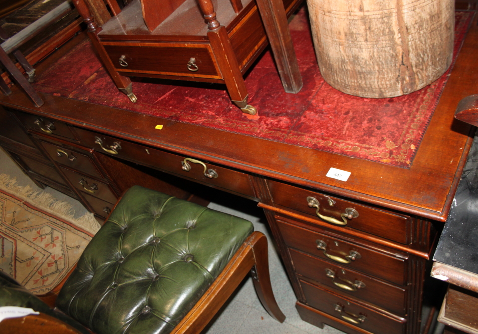 An Edwardian pedestal desk with red tooled leather lined top, fitted nine drawers, on bracket