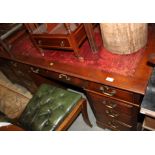 An Edwardian pedestal desk with red tooled leather lined top, fitted nine drawers, on bracket