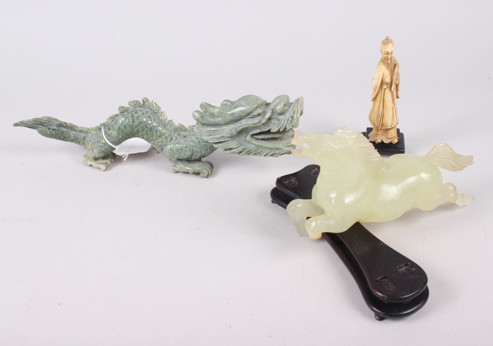 An Oriental jadeite carving of a dragon, 10" long, another jade carving of a horse (leg broken),