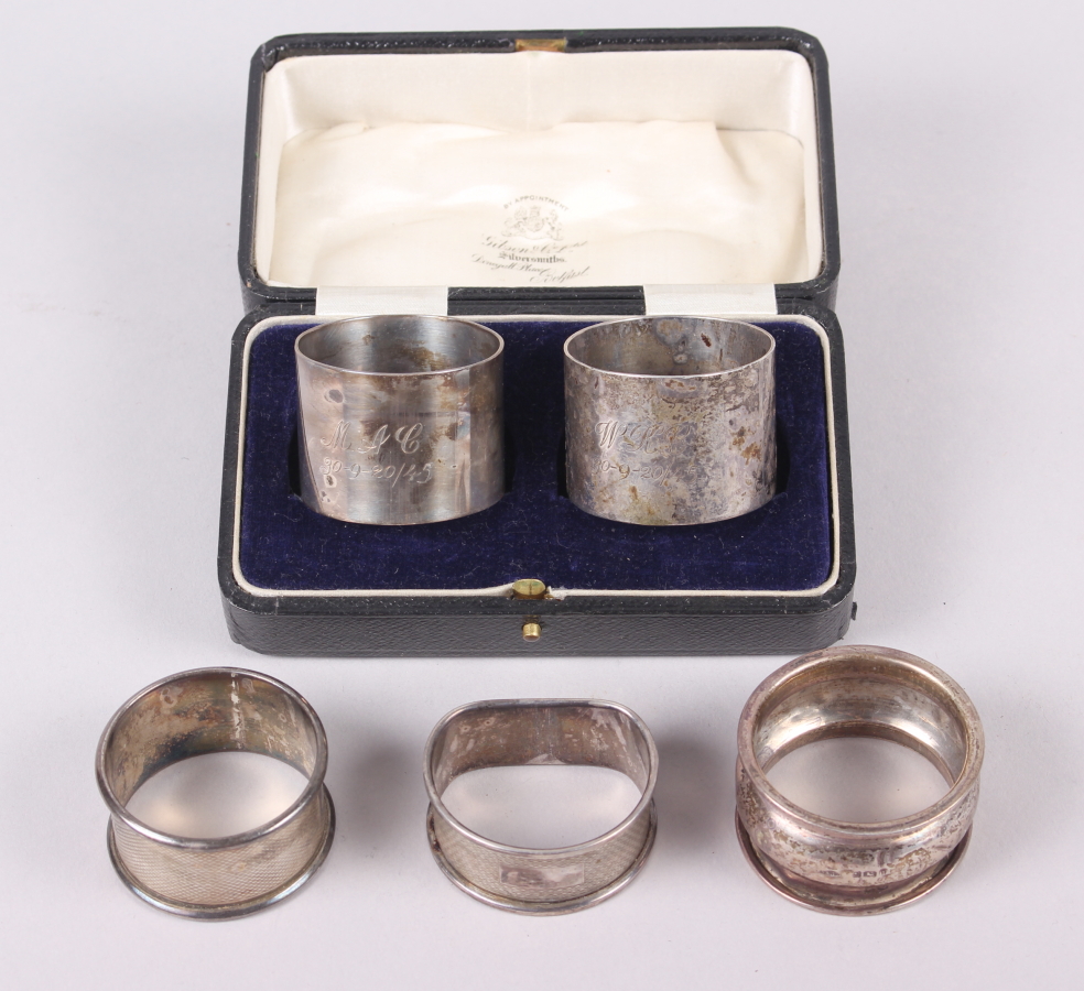 A cased pair of mid 20th century silver napkin rings, engraved initials and dated, and three other