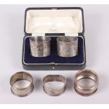 A cased pair of mid 20th century silver napkin rings, engraved initials and dated, and three other