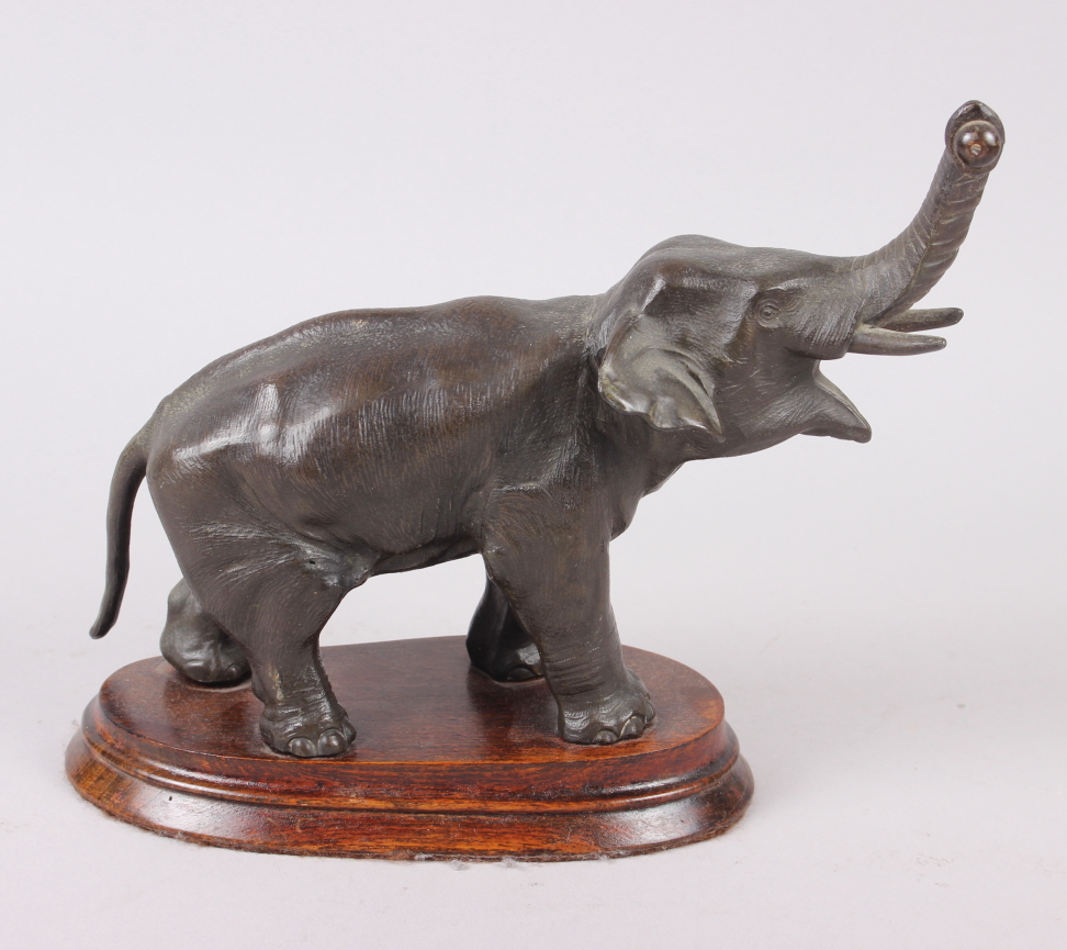 A Spelter model of an elephant, on oak stand, 8" high