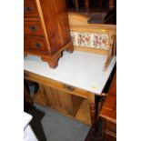 An Edwardian ash and marble top washstand with tile ledge back, fitted one long drawer and cupboard,