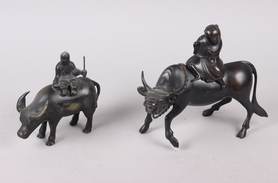 Two Chinese bronze models of figures on the back of buffalos, larger 6 1/4" high