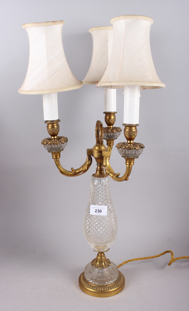 A gilt metal three-light candelabrum with cut glass body fitted electric light