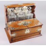 An early 20th century oak tantalus with silver plated mounts, fitted two hinged flaps enclosing