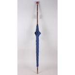 A lady's parasol with blue cover, Malacca shaft and china pommel