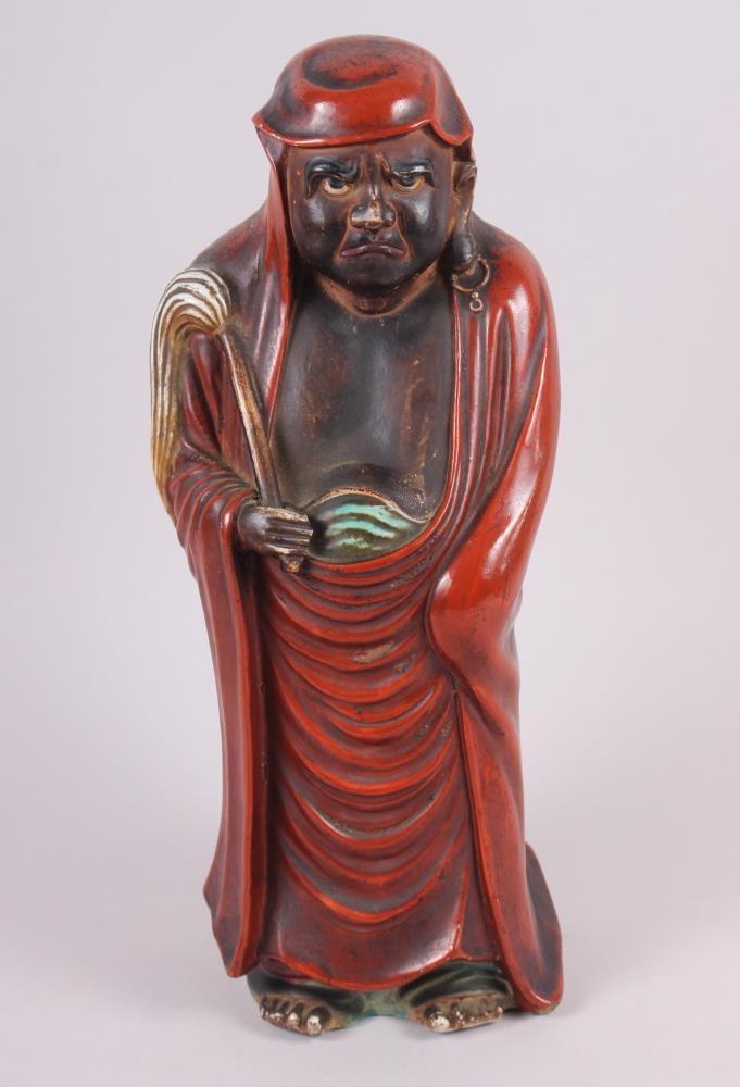 A Chinese porcelain figure of Daruma with a fly whisk, 15" high