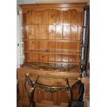 A pine dresser with boarded back fitted three shelves and base fitted two drawers and cupboard