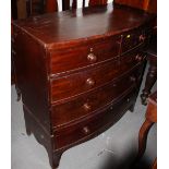 An early 19th century mahogany bowfront chest of two short and three long drawers with turned wooden