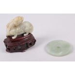 A Chinese carved jade model of a dragon, on hardwood stand, 3 1/4" high overall, and a carved jade