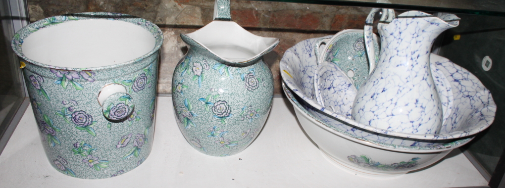 A Chintz decorated toilet set and another similar with blue marbled decoration
