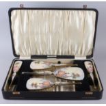 An Art Deco five-piece gilt metal and enamel brush set, backs decorated woman in a garden, in fitted