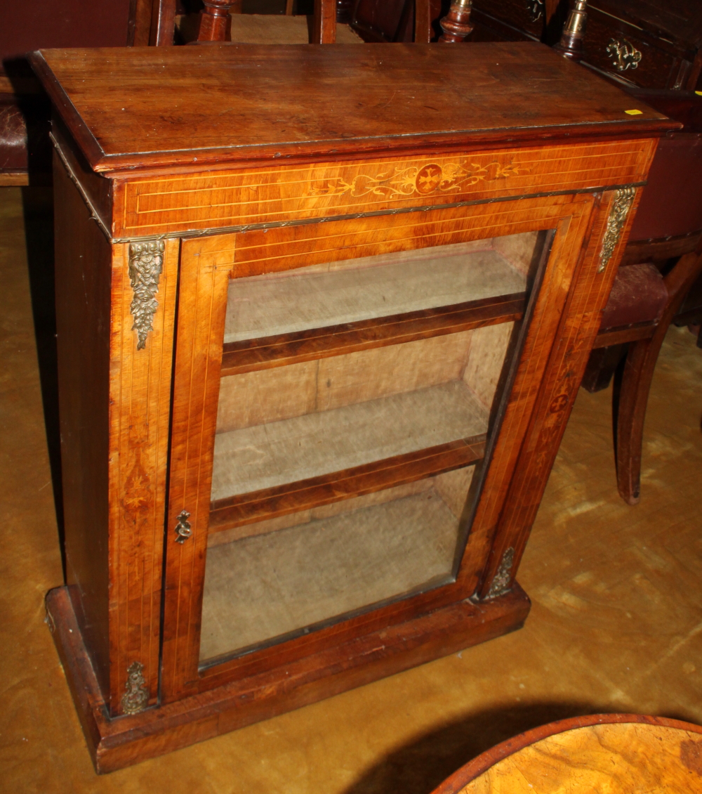 A Victorian inlaid walnut pedestal display cabinet with single glazed door, inlaid frieze and gilt