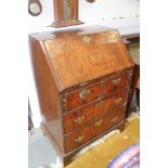 An early 18th century crossbanded walnut bureau with stepped interior and two short and two long