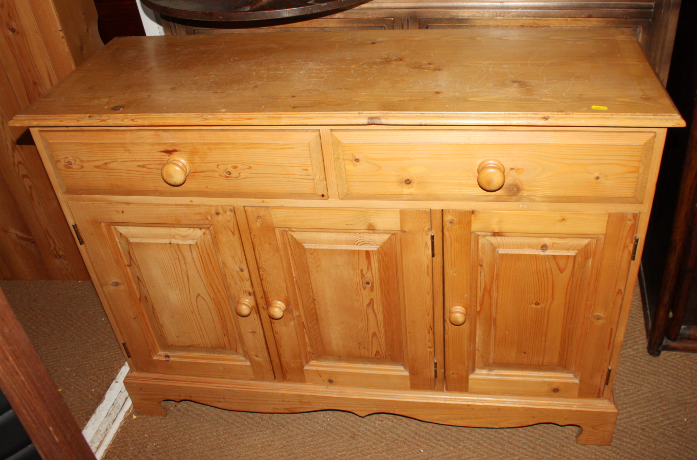 A plain stained pine blanket box, 32" wide, and another brown stained box