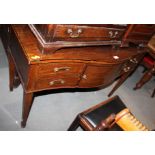 A bowfront mahogany side table with plate glass protector, fitted central cupboard and four drawers,