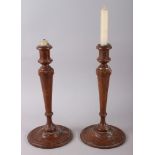 A pair of turned oak candlesticks, 12" high, and three framed landscape prints