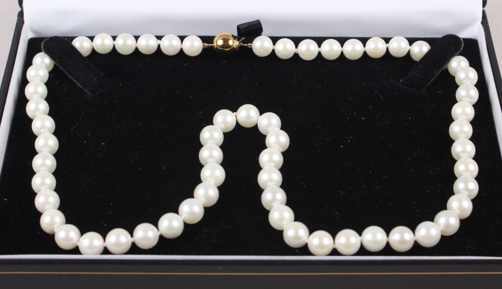 A string of uniform cultured pearls with yellow metal globular clasp, stamped 375, 17 1/22 long