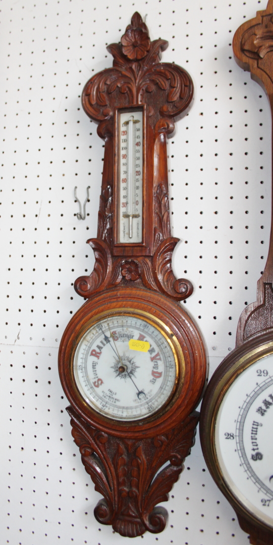 A Victorian aneroid barometer and thermometer, in carved oak case, 27" high