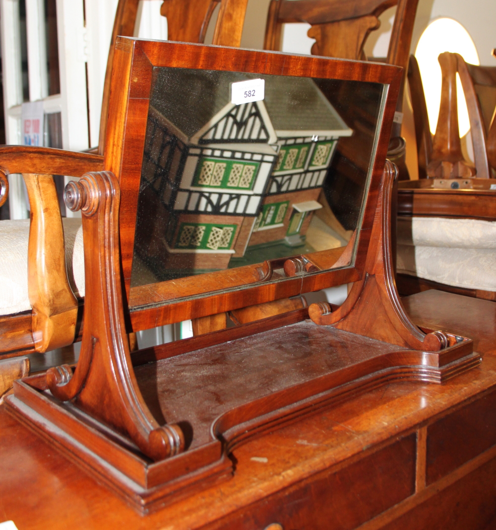 A 19th century mahogany swing frame toilet mirror, on scroll standards and tray base, 20" wide