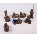 Four Bavarian Black Forest carved wooden salts, various, a similar pen stand and two others