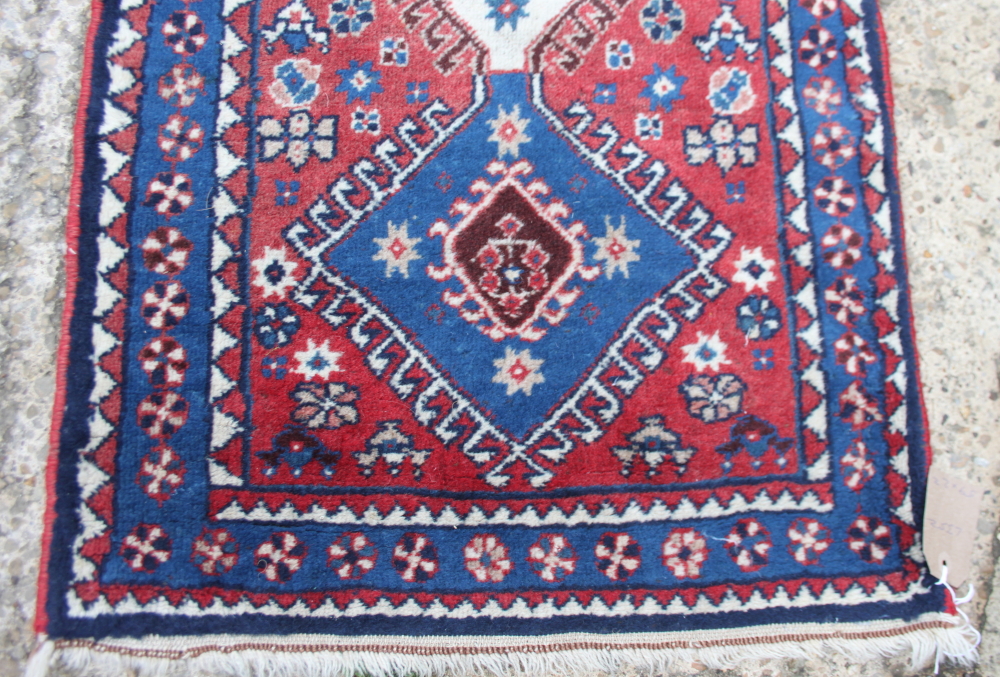 A Persian rug decorated five central conjoined medallions on a red floral ground with three border - Image 2 of 3