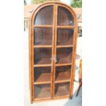A dark stained bamboo framed two-door display cabinet with arched top, 33" wide