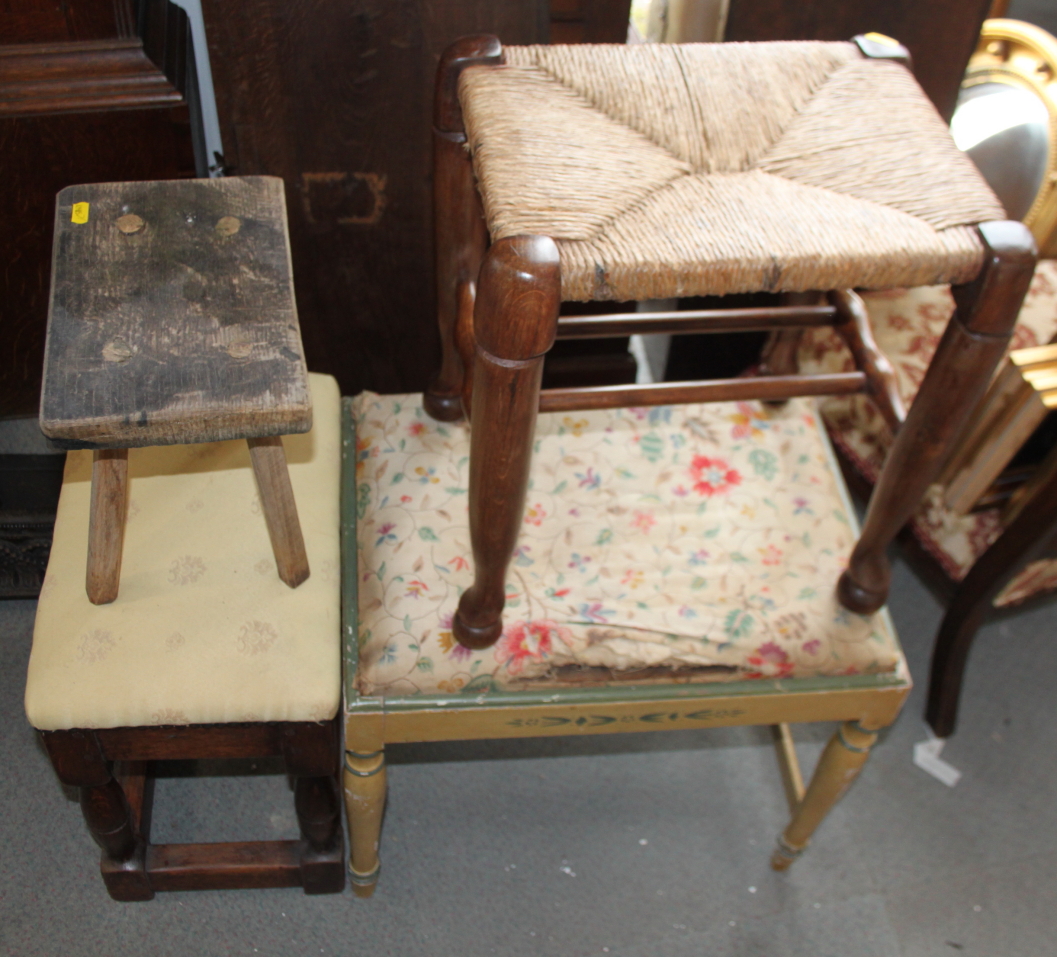 An oak framed stool, upholstered in a yellow fabric, a cane seat stool, a cream painted stool and