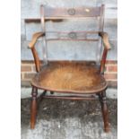 An early 19th century Windsor kitchen armchair, top and back rails carved roundels, cut down