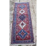 A Persian rug decorated five central conjoined medallions on a red floral ground with three border