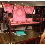 An Edwardian high backed two-seat settee, decorated spindle turned panels, upholstered in a red