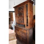 A waxed pine dresser, the upper section enclosed lattice glazed doors over two drawers and cupboards