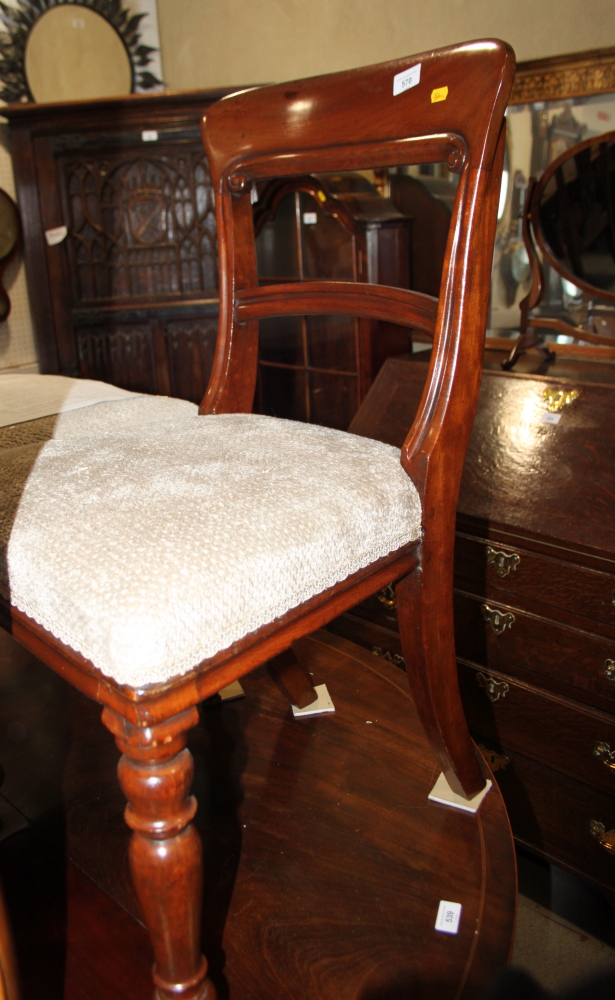 A set of four 19th century mahogany dining chairs with plain top and back rails and stuffed over