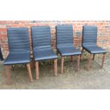 A set of four contemporary dining chairs with seats upholstered in a black faux leather