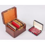 A leather playing card box, two bezique markers, a cased set of four sterling silver bridge