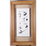 A panel of Japanese calligraphy, on floating mount, in pine strip frame