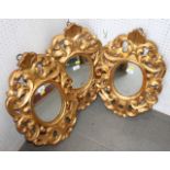 A set of three oval wall mirrors, in gilt frames with open scrollwork decoration, 23" x 15"