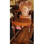 A George IV carved mahogany hall chair with scroll back and panel seat, on turned supports