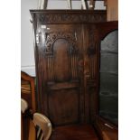 A 17th century design oak two door wardrobe with carved panelled doors and sides, 39" wide